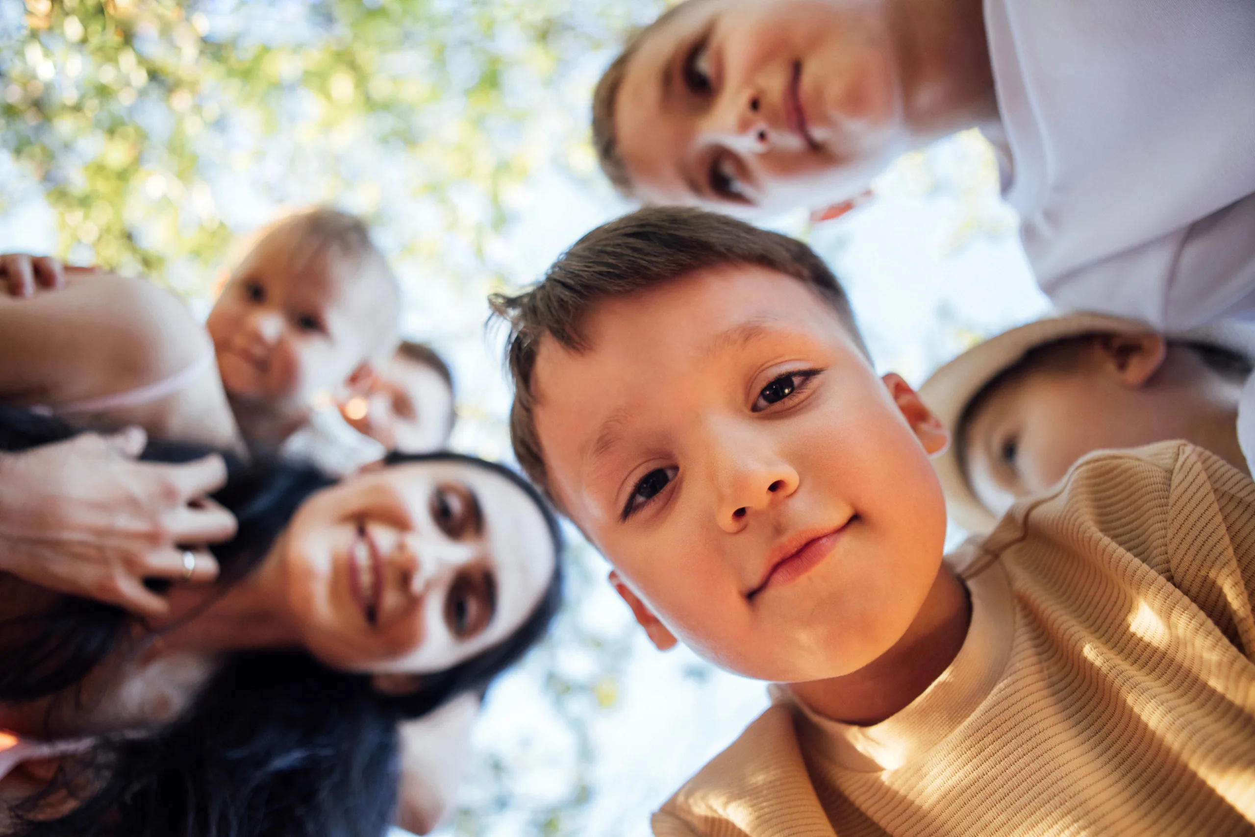 Kinderen en een moeder kijken lachend in de camera